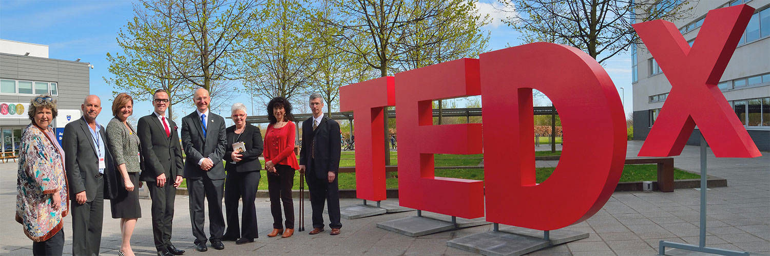 QMU staff and friends with the big Ted-X sign