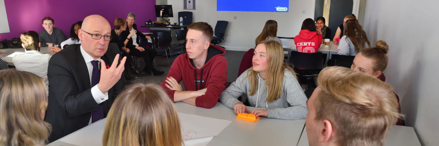 John Swinney talking to a table of students at QMU, Edinburgh