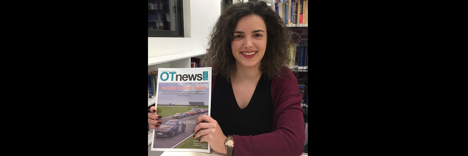 Katerina holding a copy of OT News