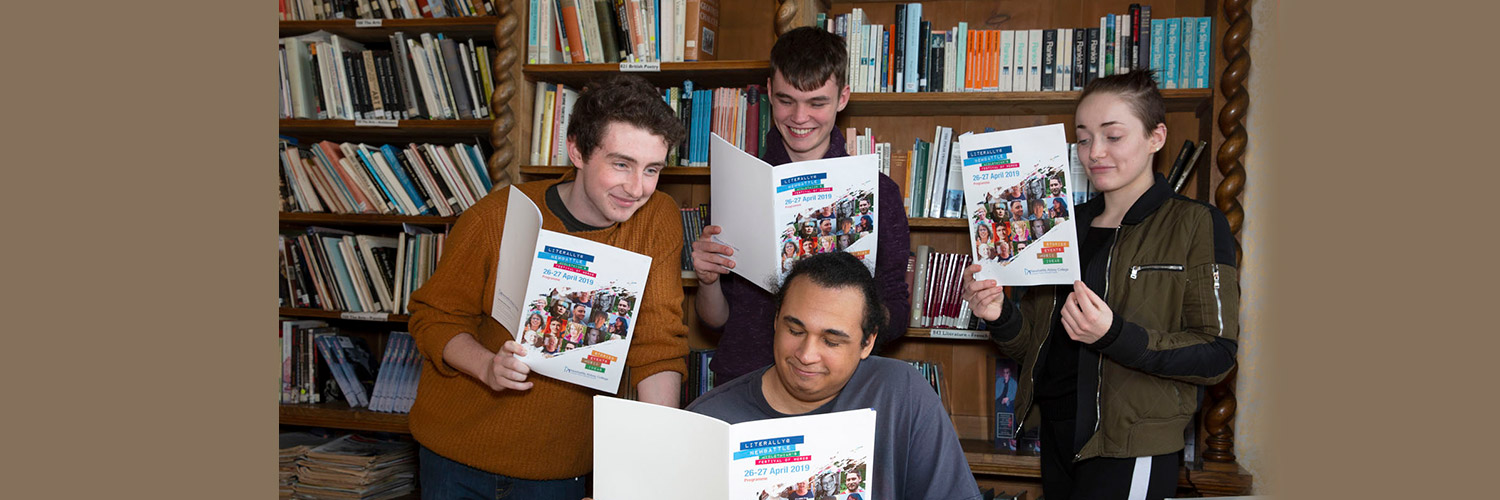 A group of students reading Newbattle magazine