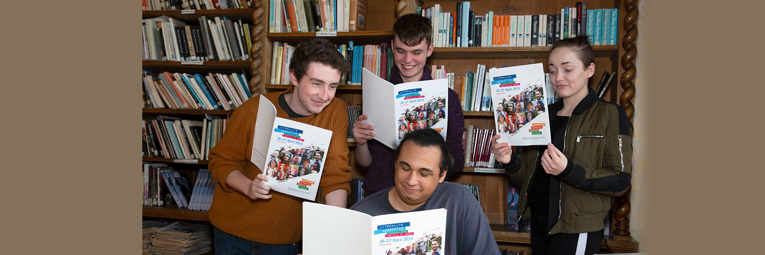 A group of students reading Newbattle magazine