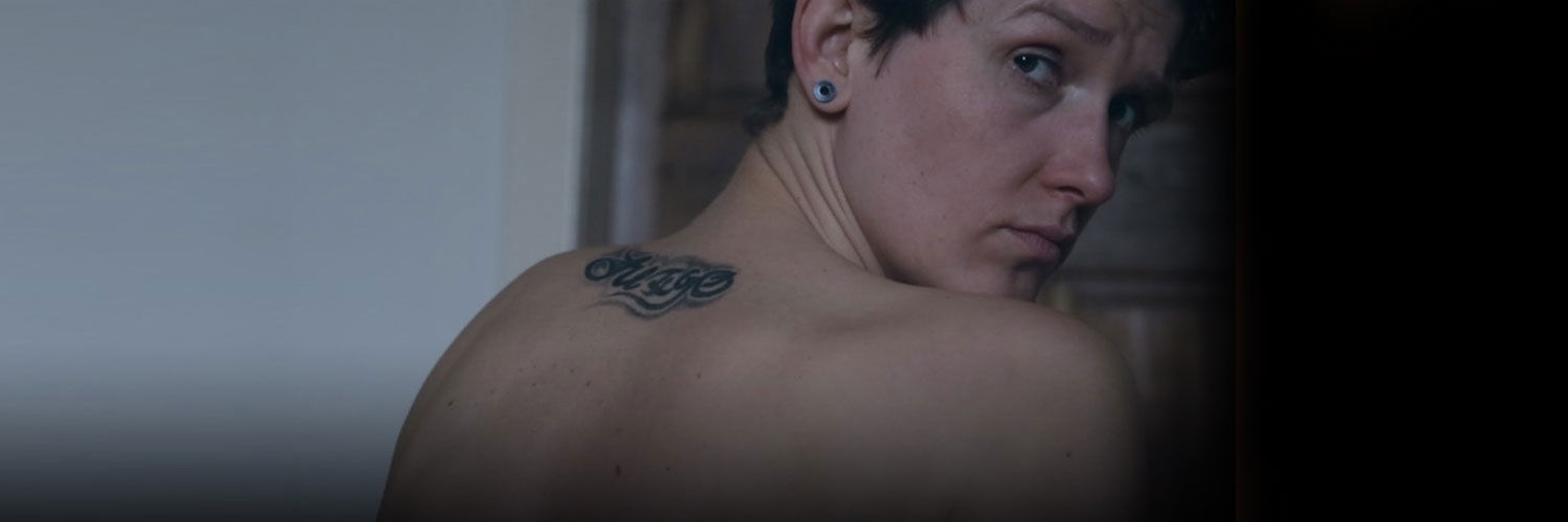A mysterious tattooed man looking over his shoulder