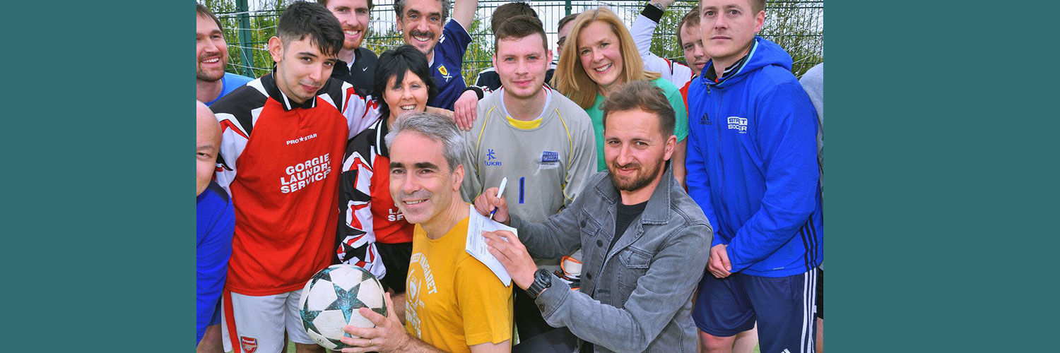 Professor Richard Butt posing with members of Street Soccer Scotland