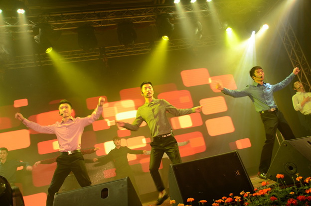 A boy band singing and performing together on stage