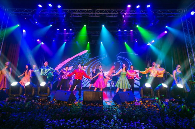 A stage filled with performers singing together