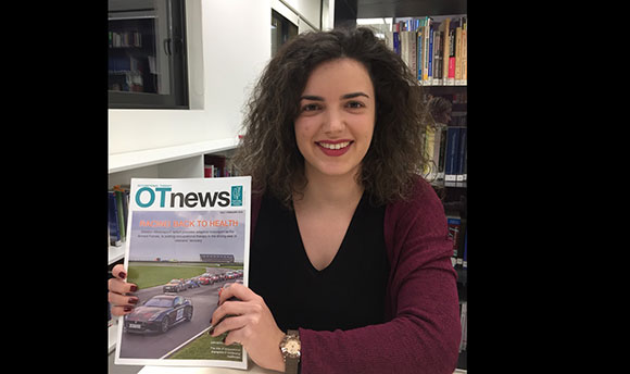 Katerina holding a copy of OT News