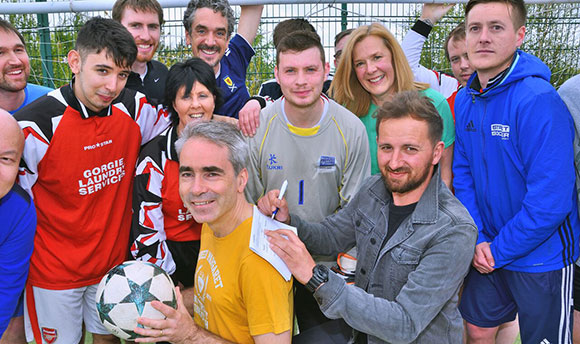 Professor Richard Butt posing with members of Street Soccer Scotland