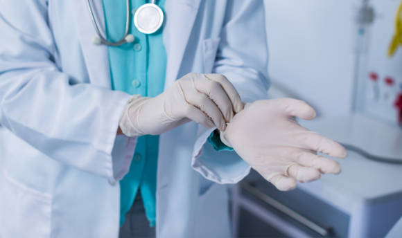 A doctor putting on rubber gloves