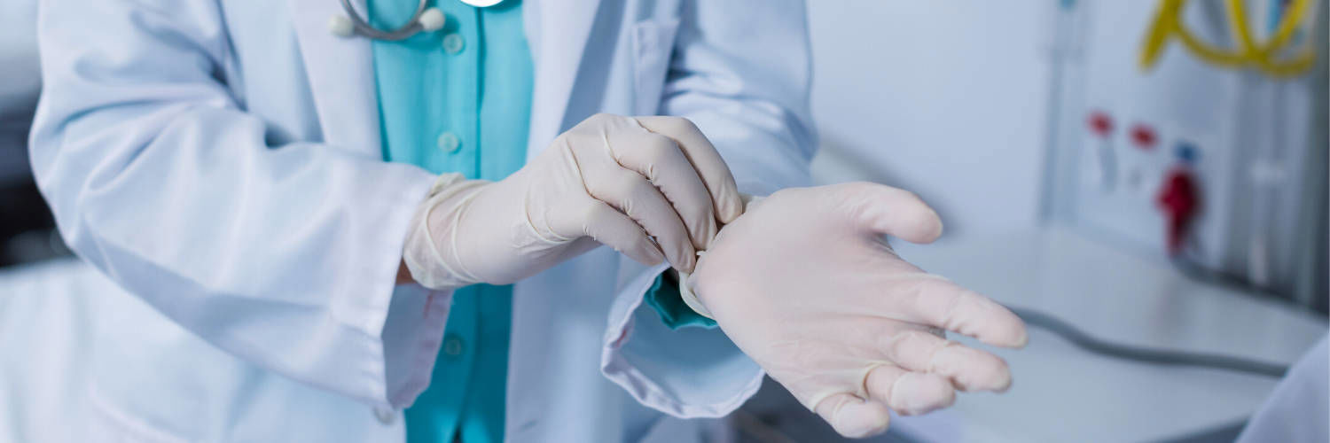 A doctor putting on rubber gloves