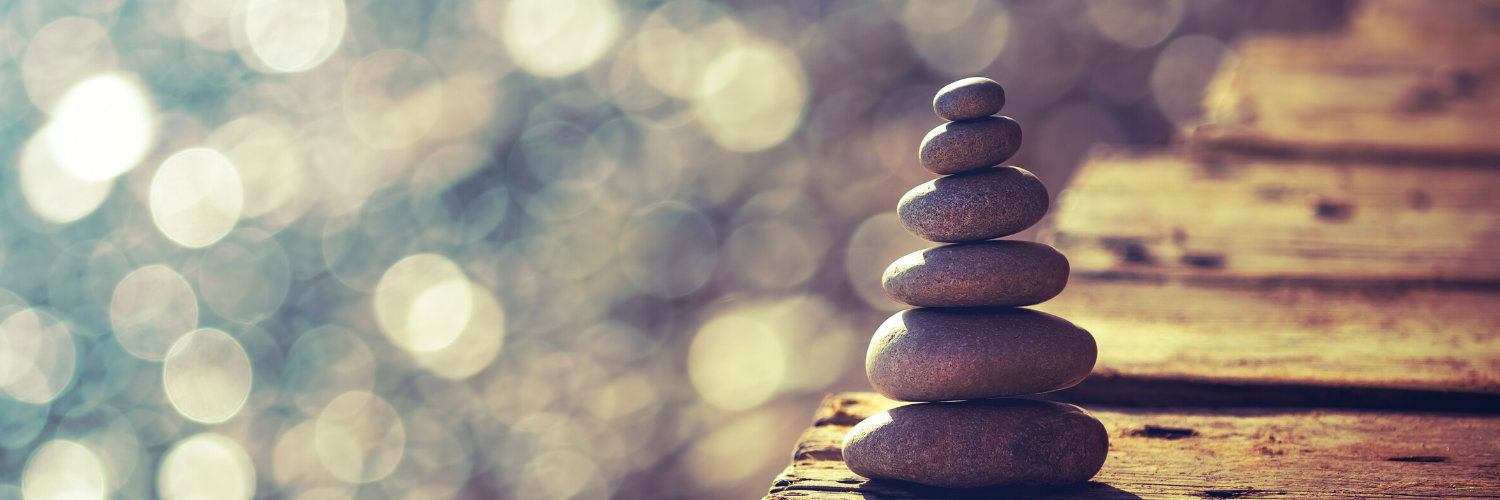 A cairn of stacked rocks against a glittering background