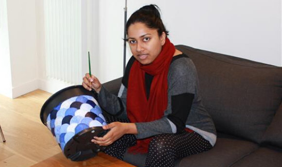 Prema Howard, holding a bucket she appears to be painting