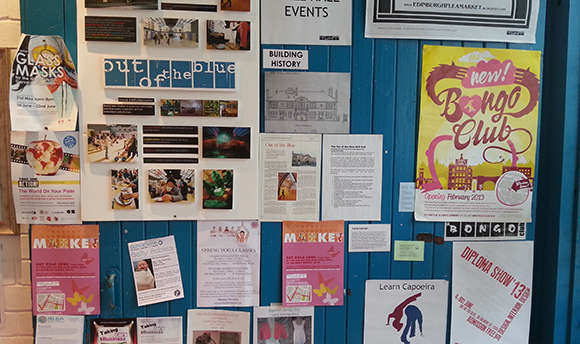 A pin board of posters and adverts