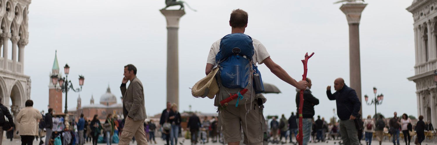 A tourist in a busy city square carrying a backpack