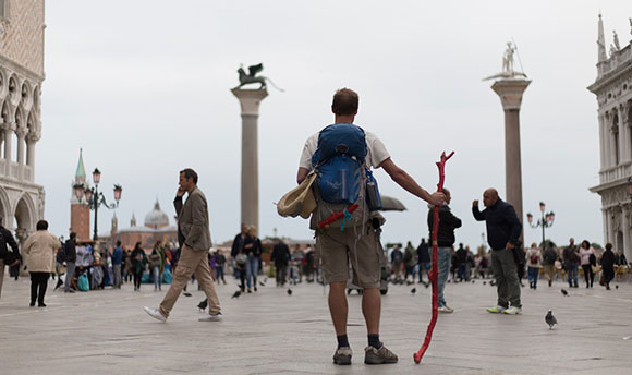 A tourist in a busy city square carrying a backpack