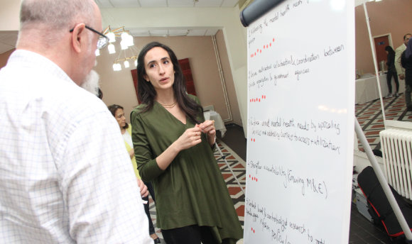 A woman beside a whiteboard, deep in conversation with a gentleman