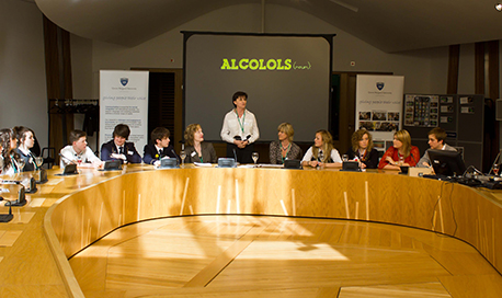 A panel being led with a large screen showing information relating to alcohol
