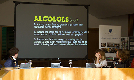 A panel being led with a large screen showing information relating to alcohol