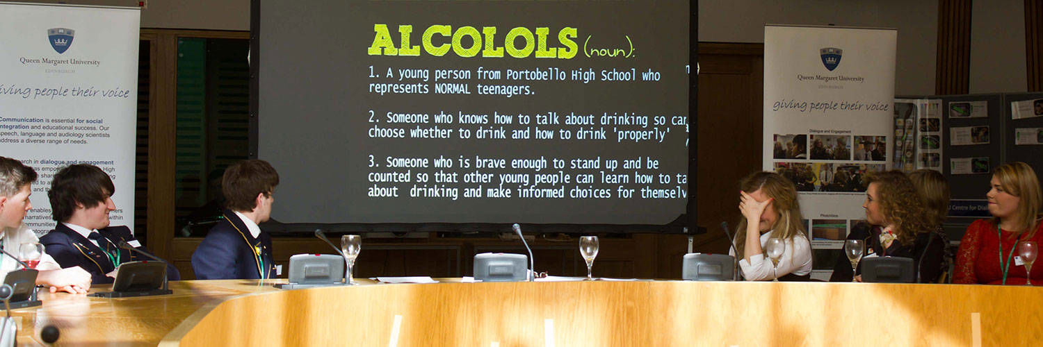 A panel being led with a large screen showing information relating to alcohol