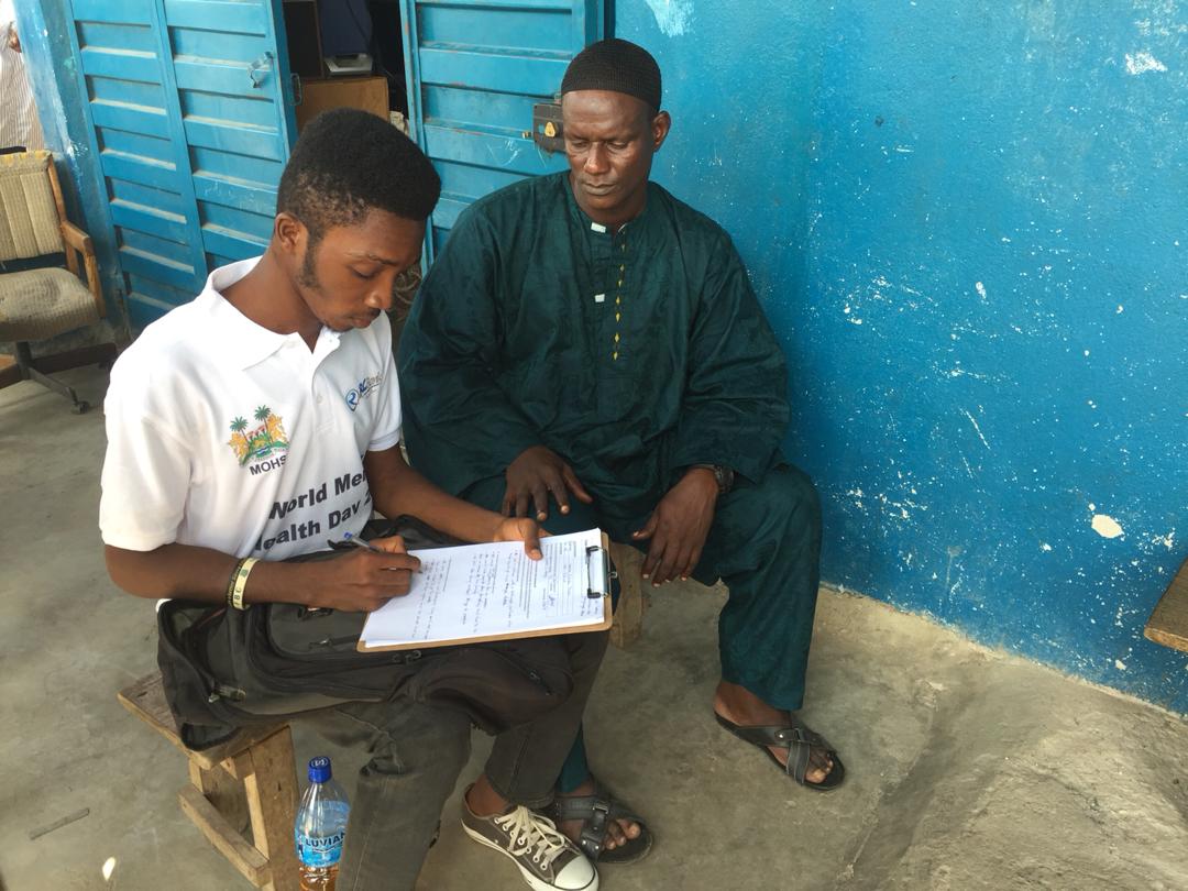 Simeon S. Sesay interviewing a community member in Kono 