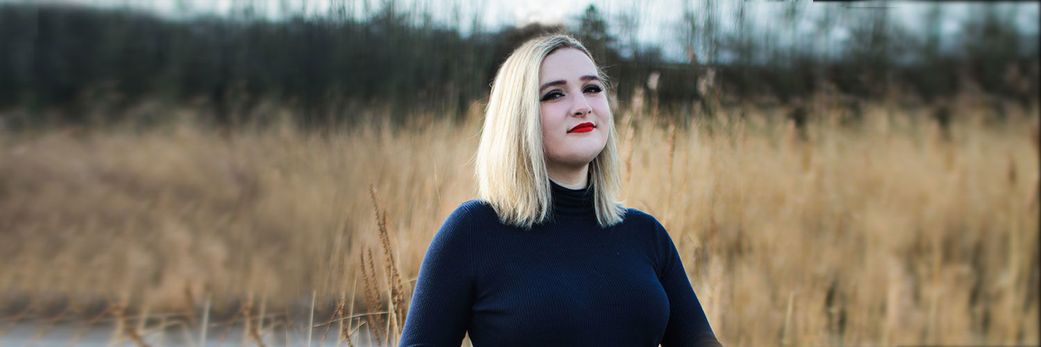 A young blonde woman in a field