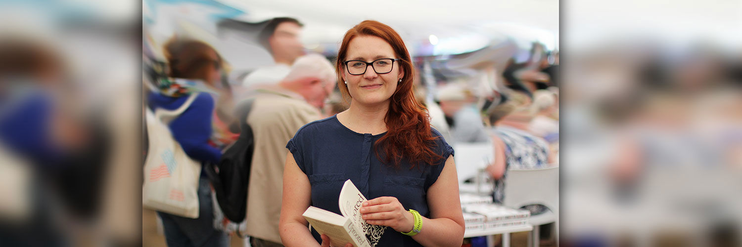A young ginger woman holding a book