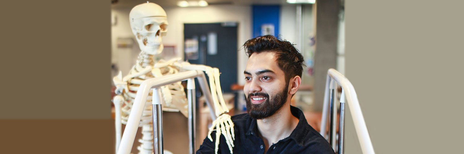 Jay Chouhan posing beside a model skeleton