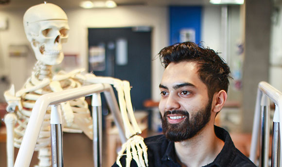 Jay Chouhan posing beside a model skeleton