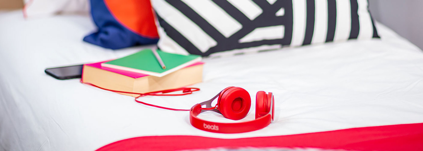 Two books and a pair of headphones lying on a bed in Queen Margaret University campus accommodation