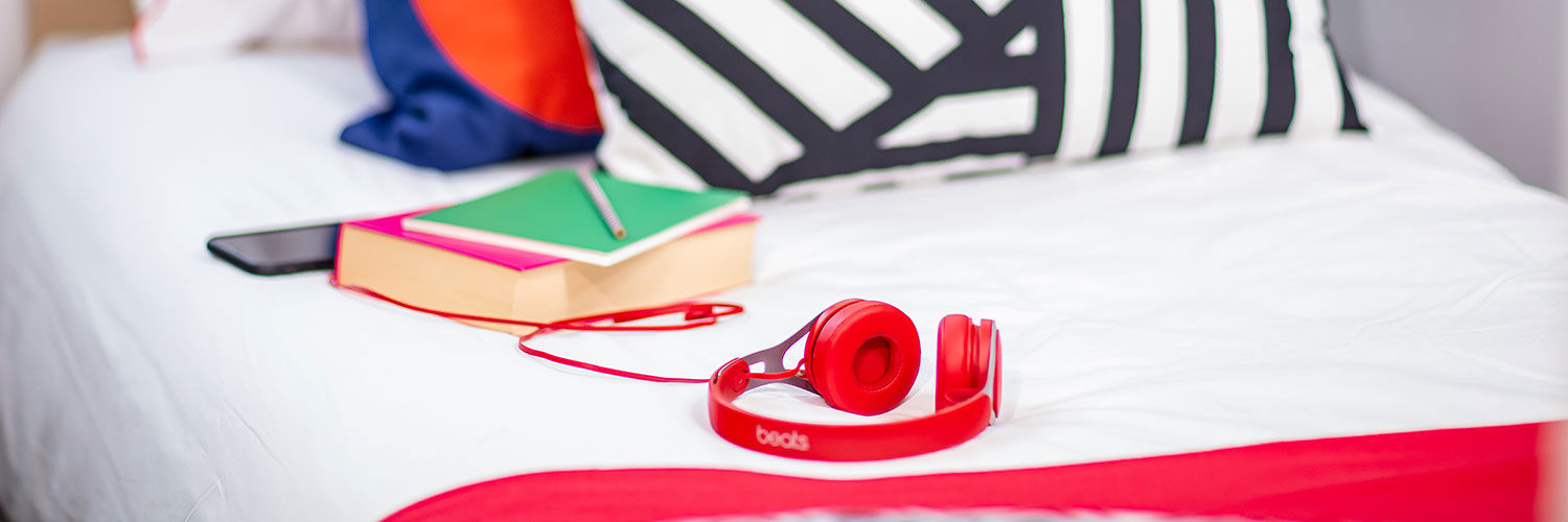 Two books and a pair of headphones lying on a bed in Queen Margaret University campus accommodation
