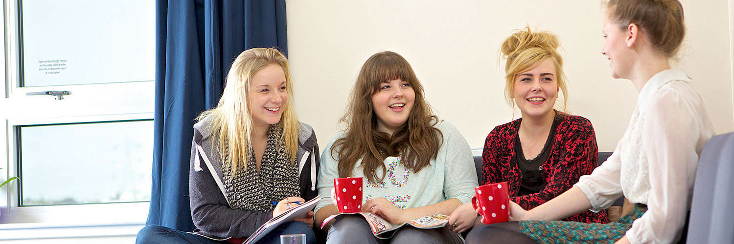 A group of young QMU students on a sofa chatting