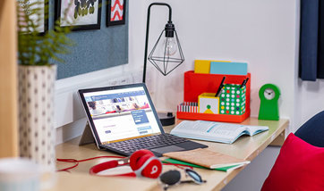 A laptop and headphones on a student desk in Queen Margaret University accommodation