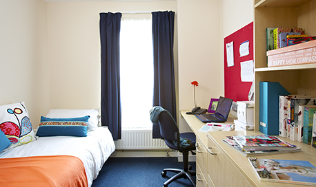 A standard room layout, with a single bed, en-suite, wardrobe and desk