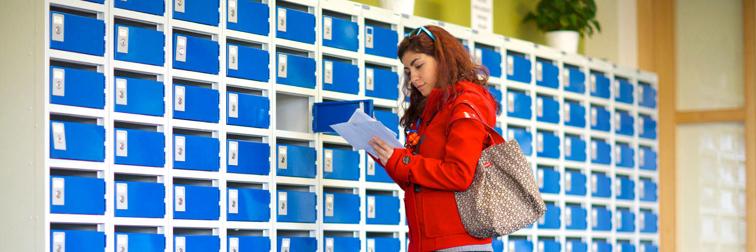 A student taking her mail out of the lockers in the common area