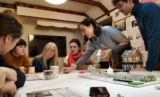 A group of people sat at a table, working on a project together