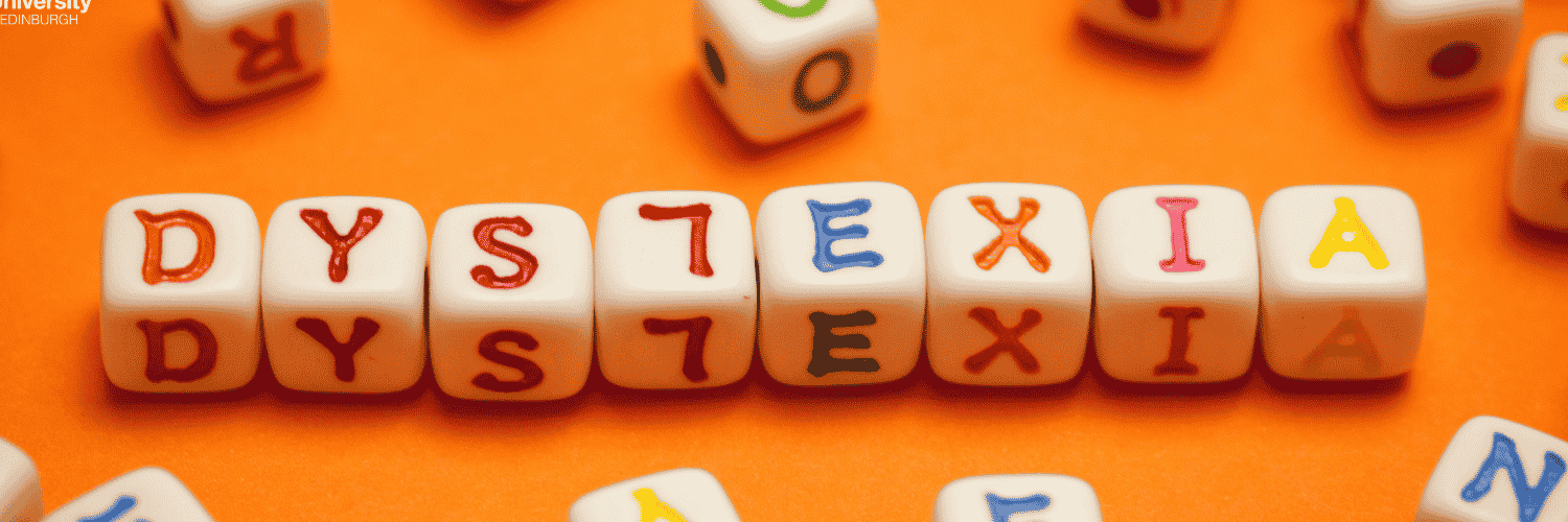 dyslexia spelled out with letters on small cubes over an orange background 