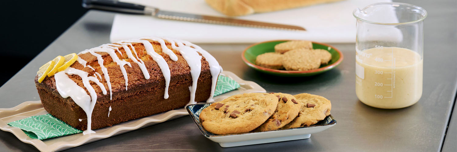 A loaf of bread, a plate of cookies, some biscuits, and a loaf cake created using an alternative to palm oil.