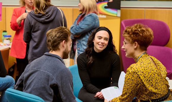 Two prospective students speaking with a lecturer at an Open Day event.