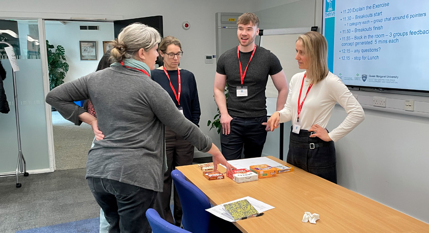 Five people discussing food products in front of them
