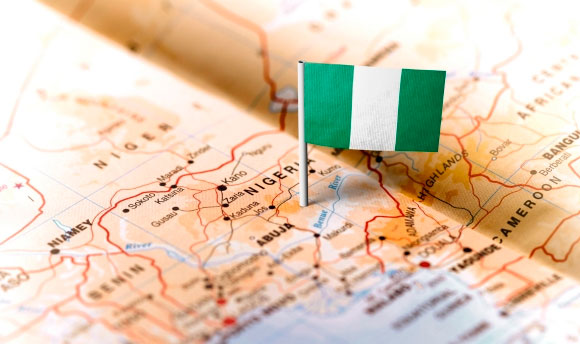 Nigerian flag placed on top of a map of Nigeria