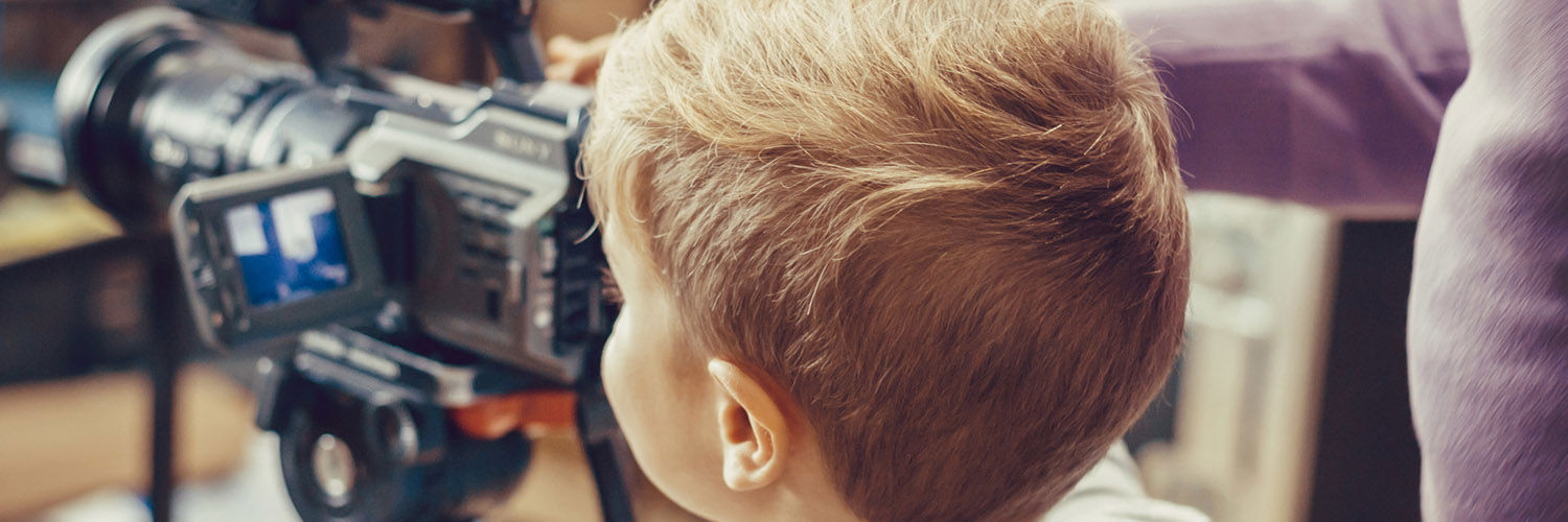 Little boy using a video camera