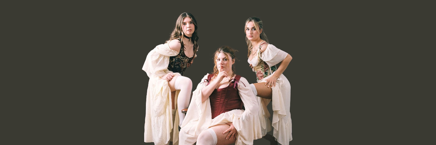 Three people in period costume clothing pose for a photograph.