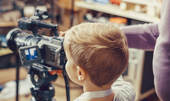 Little boy using a video camera