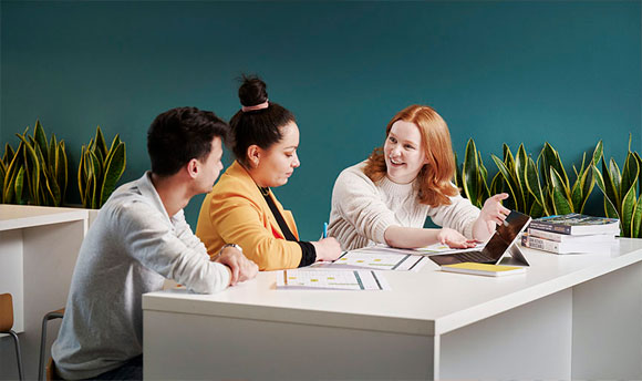 A group of people sat at a table, working on a project together.