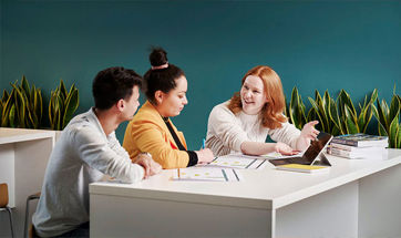 A group of people sat at a table, working on a project together.