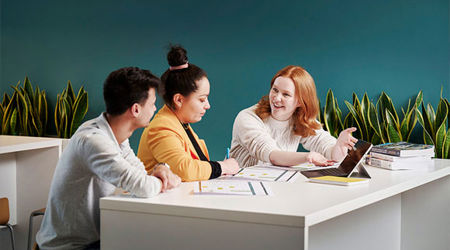 A group of people sat at a table, working on a project together.