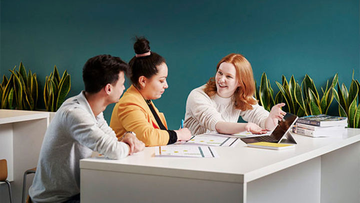 A group of people sat at a table, working on a project together.