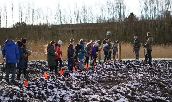 Group of children planting trees on QMU campus