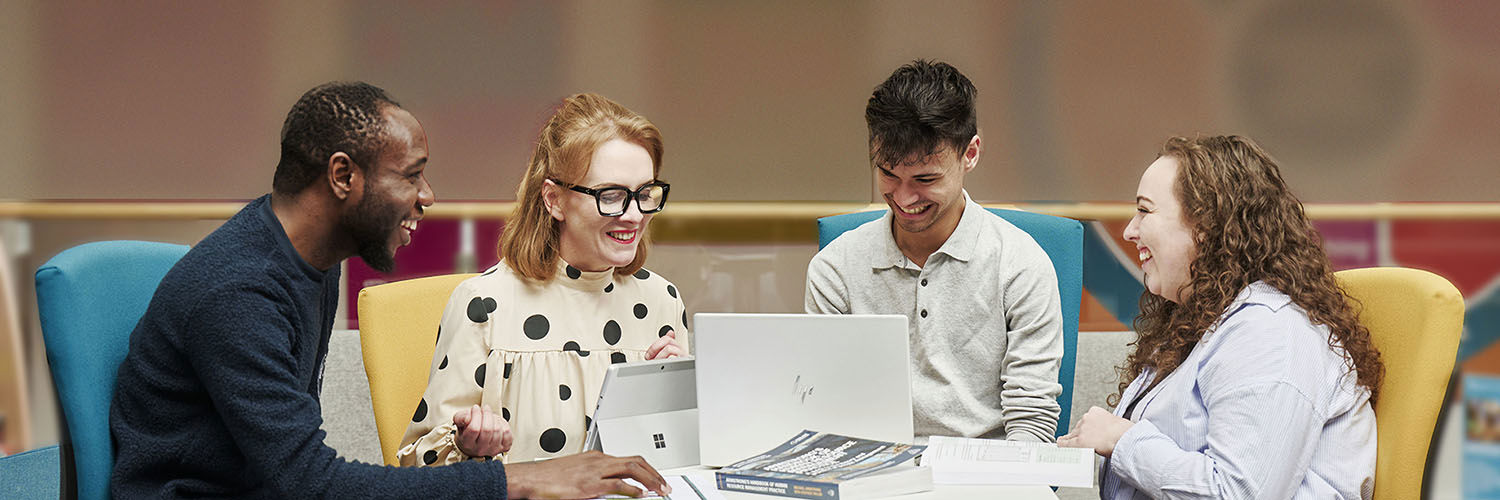 Happy colleagues chatting and working around a desk