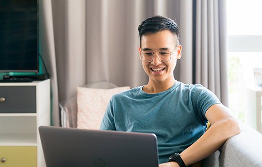 smiling prospective student working on laptop