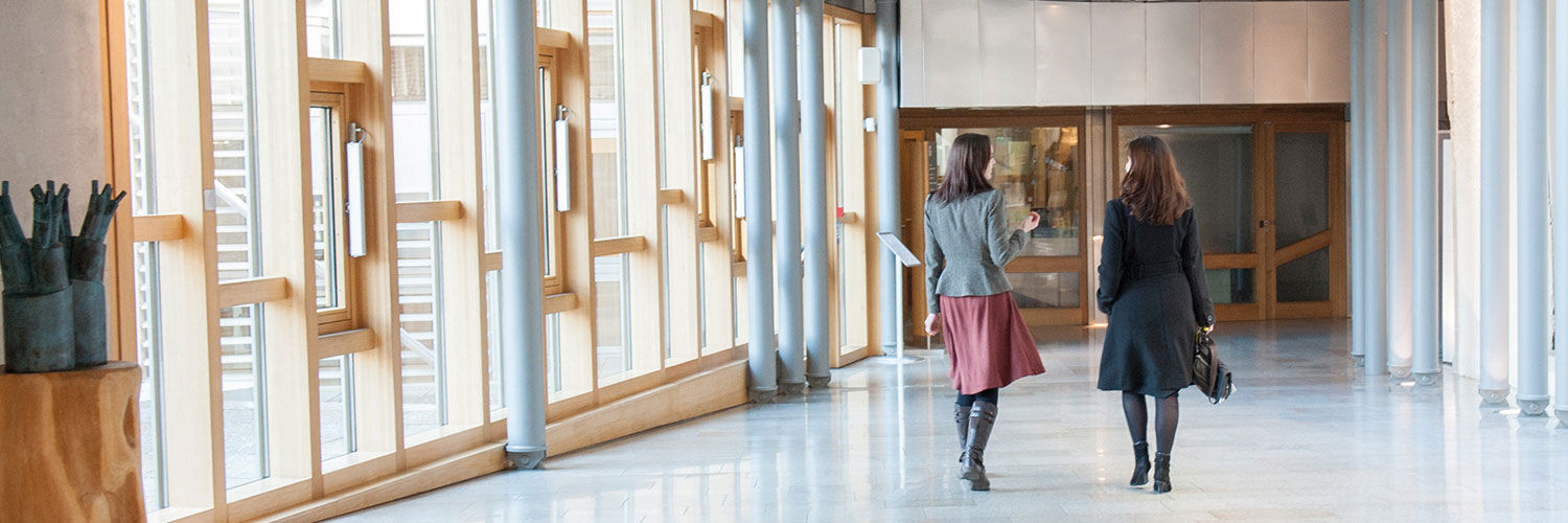 Two women walking down a corridor
